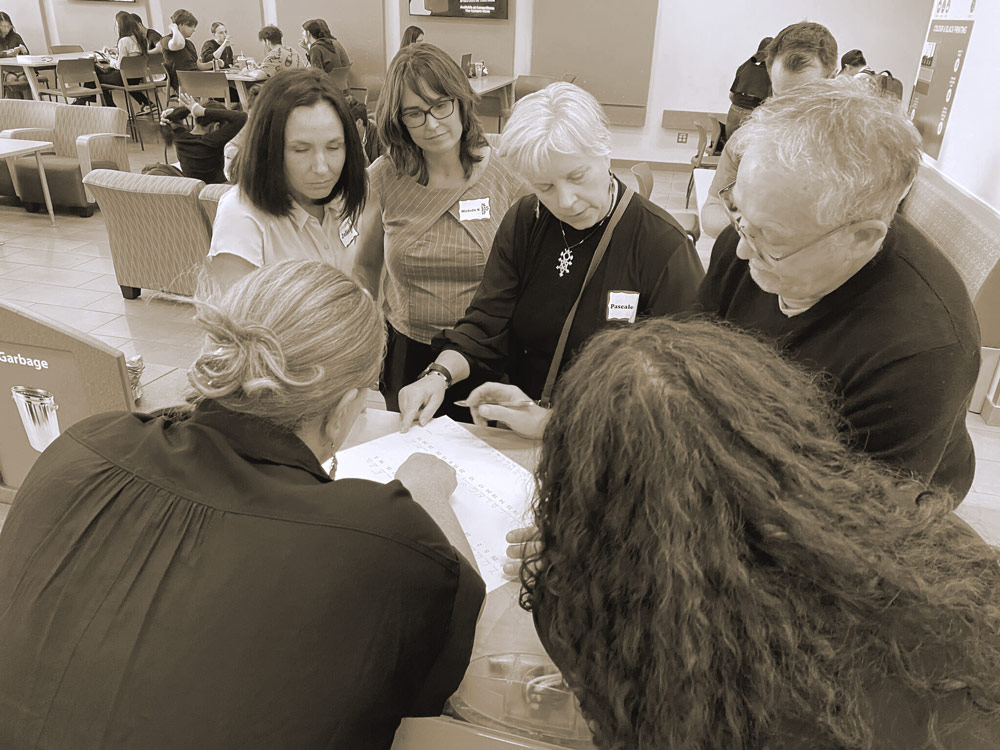 CICan Staff huddled together reviewing document
